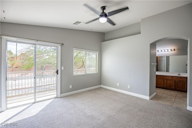 1155 Heavenly Harvest Pl Unit 3, Henderson, NV 89002 - unfurnished bedroom with access to exterior, light carpet, arched walkways, ensuite bath, and ceiling fan