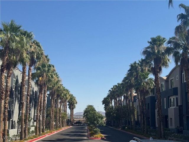 9050 W Tropicana Ave Unit 1015, Las Vegas, NV 89147 - view of asphalt road featuring curbs, street lights, and a gated entry