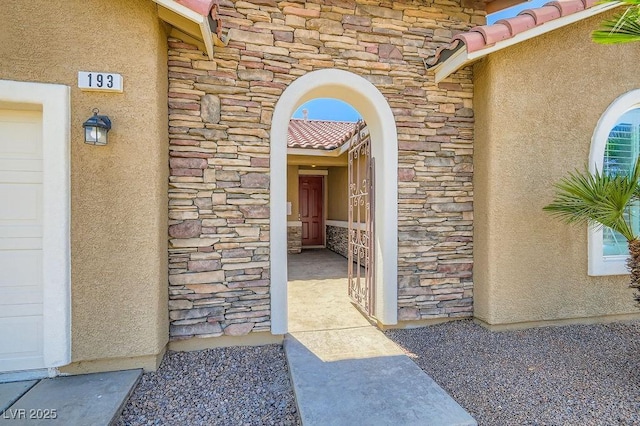 193 Lynbrook St, Henderson, NV 89012 - property entrance with stone siding, stucco siding, and a tiled roof