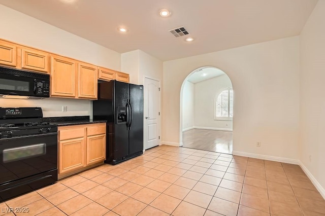 193 Lynbrook St, Henderson, NV 89012 - kitchen with black appliances, arched walkways, light tile patterned floors, dark countertops, and light brown cabinetry