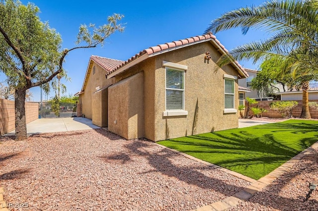 193 Lynbrook St, Henderson, NV 89012 - view of side of home featuring stucco siding, a tiled roof, and a patio
