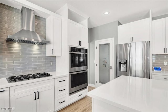 7816 Red Leaf Dr, Las Vegas, NV 89131 - kitchen with appliances with stainless steel finishes, wall chimney range hood, decorative backsplash, light countertops, and white cabinetry