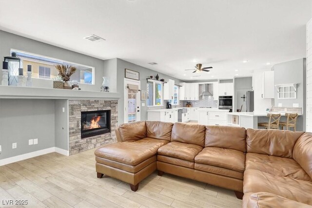 7816 Red Leaf Dr, Las Vegas, NV 89131 - living area with a stone fireplace, light wood-type flooring, recessed lighting, and ceiling fan
