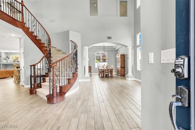 7816 Red Leaf Dr, Las Vegas, NV 89131 - foyer entrance with decorative columns, arched walkways, a high ceiling, wood finished floors, and stairway