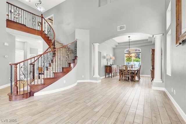 7816 Red Leaf Dr, Las Vegas, NV 89131 - entrance foyer featuring ornate columns, wood finished floors, arched walkways, a towering ceiling, and stairway