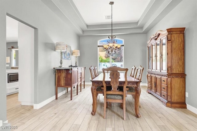7816 Red Leaf Dr, Las Vegas, NV 89131 - dining space with a chandelier, a raised ceiling, and light wood-type flooring