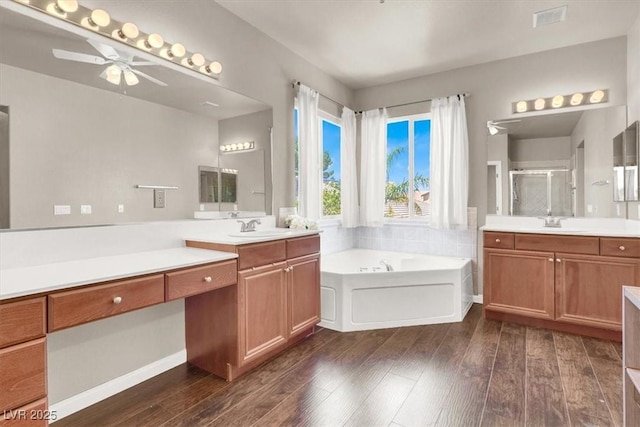 7816 Red Leaf Dr, Las Vegas, NV 89131 - full bathroom featuring ceiling fan, a stall shower, wood-type flooring, a garden tub, and two vanities