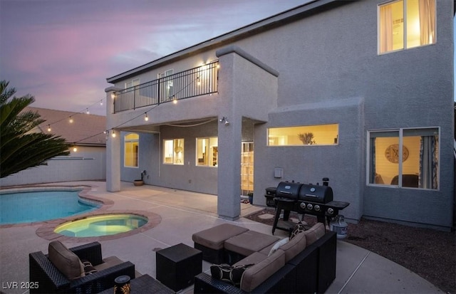 7816 Red Leaf Dr, Las Vegas, NV 89131 - back of property at dusk with a balcony, a patio, stucco siding, a pool with connected hot tub, and outdoor lounge area
