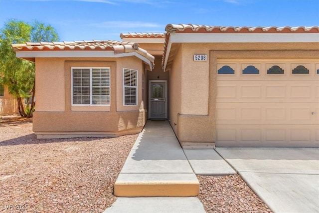 5208 Regena Rose St, North Las Vegas, NV 89081 - view of front of property featuring stucco siding, an attached garage, a tile roof, and driveway