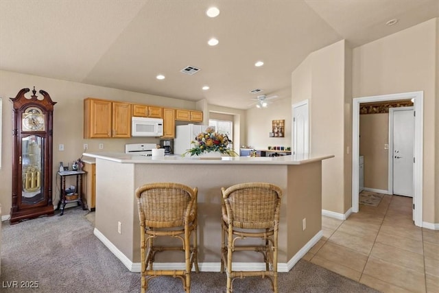 5208 Regena Rose St, North Las Vegas, NV 89081 - kitchen with white appliances, light countertops, ceiling fan, recessed lighting, and a breakfast bar