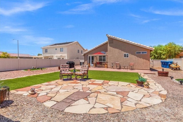 5208 Regena Rose St, North Las Vegas, NV 89081 - back of property with a patio area, a fenced backyard, stucco siding, and a tile roof