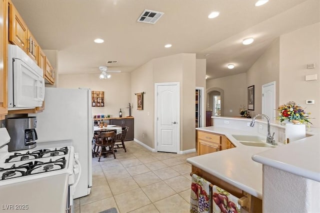 5208 Regena Rose St, North Las Vegas, NV 89081 - kitchen with white appliances, arched walkways, light tile patterned floors, recessed lighting, and a ceiling fan