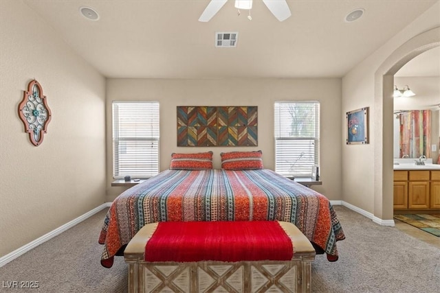 5208 Regena Rose St, North Las Vegas, NV 89081 - bedroom with light colored carpet, arched walkways, connected bathroom, and a ceiling fan