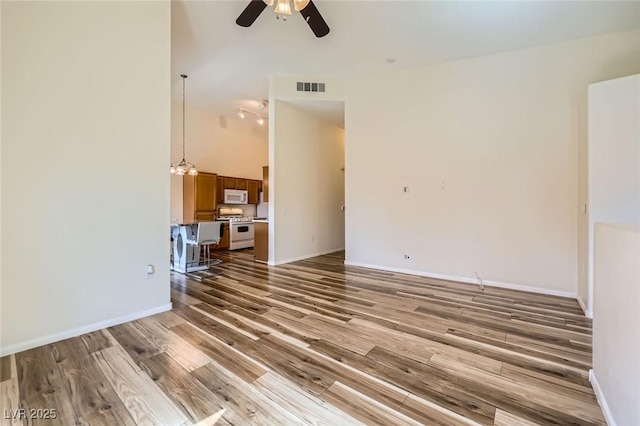 8805 Jeffreys St Unit 1089, Las Vegas, NV 89123 - unfurnished living room featuring wood finished floors, a ceiling fan, and a towering ceiling