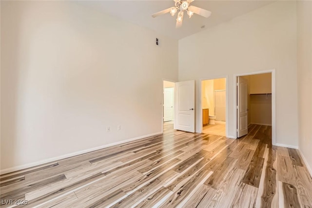 8805 Jeffreys St Unit 1089, Las Vegas, NV 89123 - unfurnished bedroom with a walk in closet, a towering ceiling, light wood-type flooring, ensuite bath, and a ceiling fan