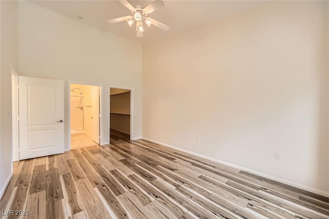 8805 Jeffreys St Unit 1089, Las Vegas, NV 89123 - unfurnished bedroom with a walk in closet, light wood-style flooring, a high ceiling, and a ceiling fan