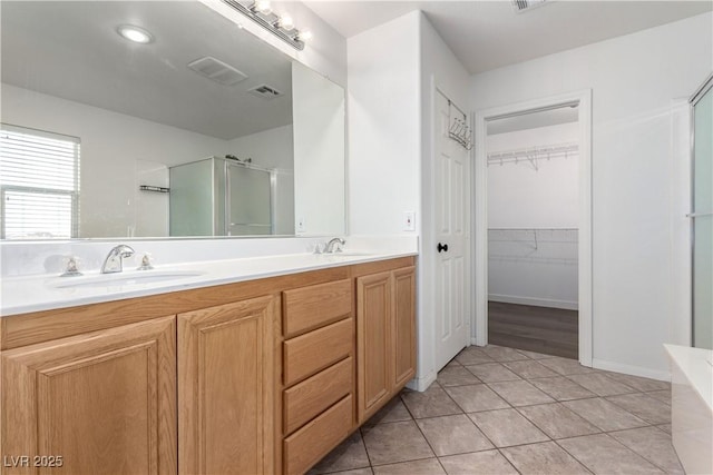 520 Ivy Spring St, Las Vegas, NV 89138 - bathroom featuring a shower stall, double vanity, tile patterned floors, and a walk in closet