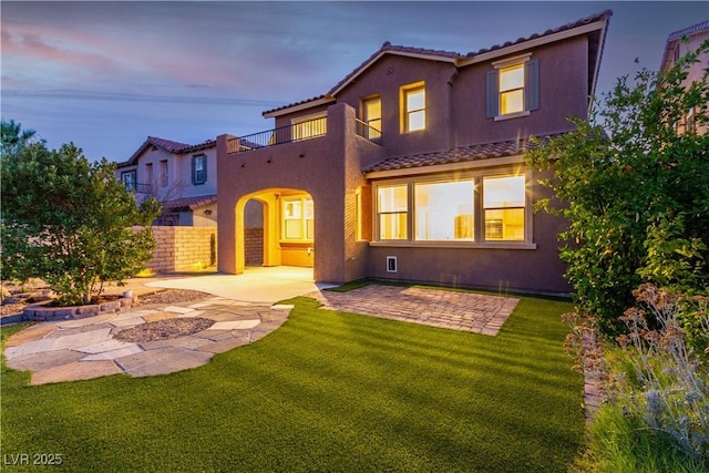 520 Ivy Spring St, Las Vegas, NV 89138 - back of house at dusk with a tiled roof, stucco siding, a patio area, and a balcony