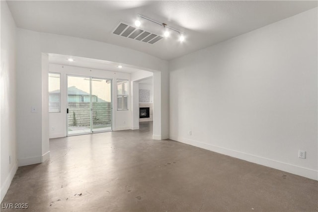 520 Ivy Spring St, Las Vegas, NV 89138 - unfurnished room featuring concrete flooring, track lighting, and a glass covered fireplace