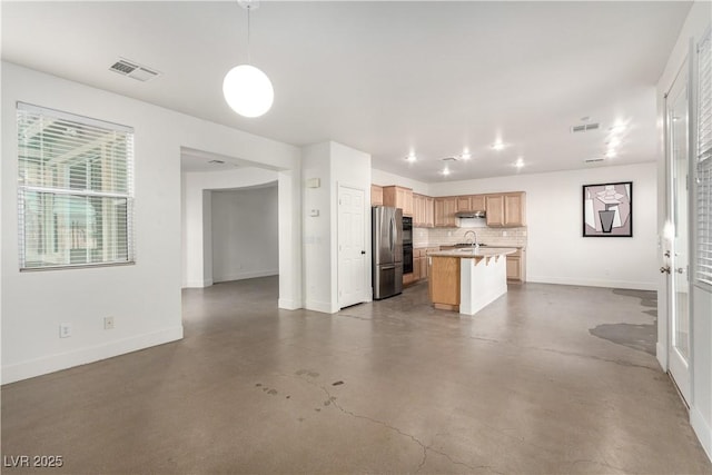 520 Ivy Spring St, Las Vegas, NV 89138 - kitchen featuring freestanding refrigerator, concrete floors, decorative backsplash, a center island with sink, and light countertops