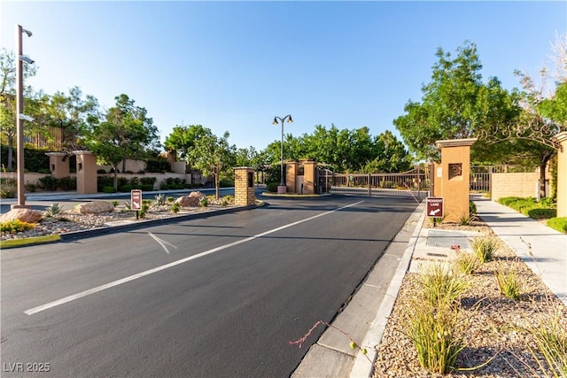 520 Ivy Spring St, Las Vegas, NV 89138 - view of asphalt street featuring street lighting, sidewalks, curbs, a gate, and a gated entry