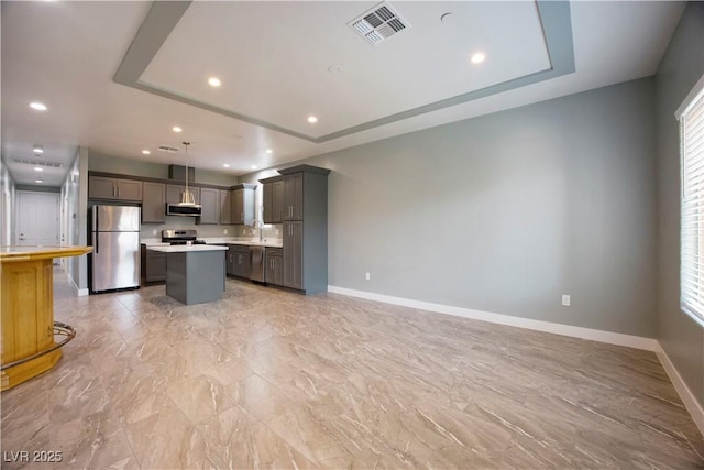 605 N Yale St, Las Vegas, NV 89107 - kitchen with appliances with stainless steel finishes, a raised ceiling, light countertops, a kitchen island, and recessed lighting
