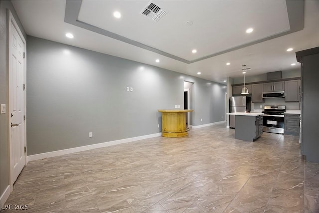 605 N Yale St, Las Vegas, NV 89107 - kitchen with stainless steel appliances, a tray ceiling, recessed lighting, light marble finish floors, and a center island