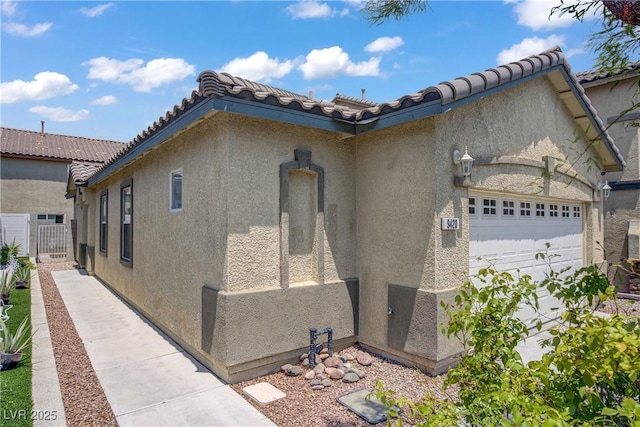 9420 Plover Falls Ave, Las Vegas, NV 89149 - view of home's exterior featuring an attached garage, stucco siding, and a tiled roof