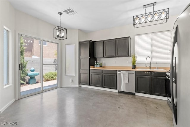 9420 Plover Falls Ave, Las Vegas, NV 89149 - kitchen featuring stainless steel appliances, concrete floors, a chandelier, light countertops, and pendant lighting