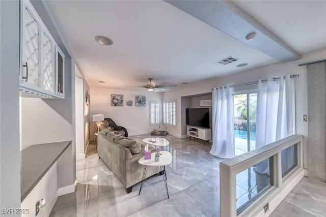 895 Beartooth Falls Ct, Henderson, NV 89052 - living area featuring healthy amount of natural light, a ceiling fan, and light marble finish flooring