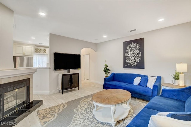 9000 Las Vegas Blvd Unit 2060, Las Vegas, NV 89123 - living room with arched walkways, a tiled fireplace, light wood-style floors, and recessed lighting
