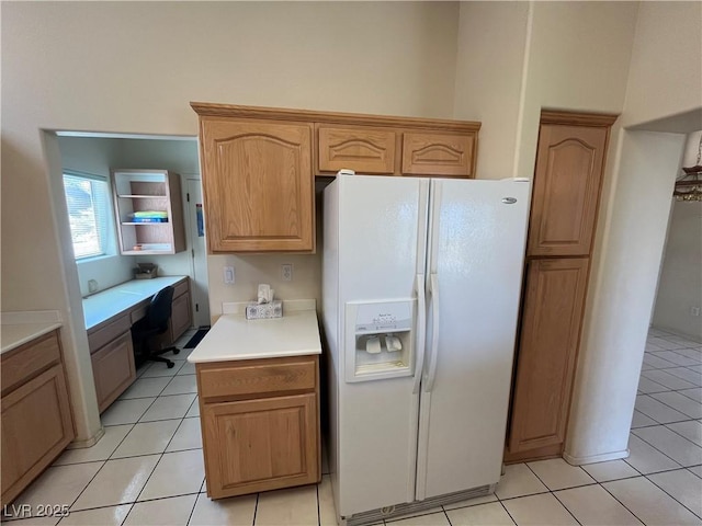 2712 Breakers Creek Dr, Las Vegas, NV 89134 - kitchen with white refrigerator with ice dispenser, built in desk, light countertops, and light tile patterned floors