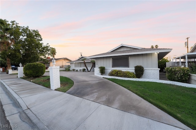 1009 Ironwood Dr, Las Vegas, NV 89108 - single story home with curved driveway, board and batten siding, a front lawn, brick siding, and a shingled roof
