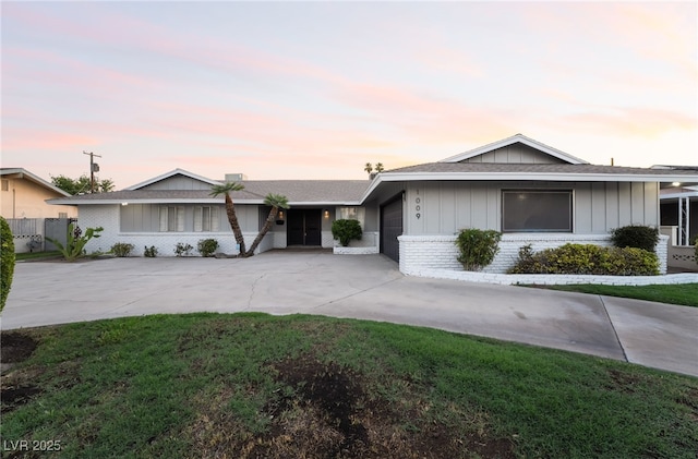 1009 Ironwood Dr, Las Vegas, NV 89108 - ranch-style home featuring a garage, concrete driveway, brick siding, board and batten siding, and a yard