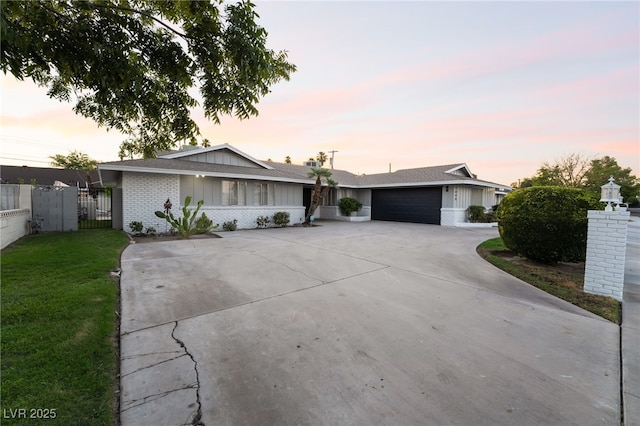 1009 Ironwood Dr, Las Vegas, NV 89108 - single story home featuring brick siding, driveway, a gate, an attached garage, and board and batten siding