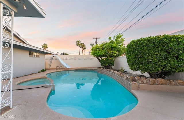 1009 Ironwood Dr, Las Vegas, NV 89108 - view of pool with a water slide, a pool with connected hot tub, a fenced backyard, and a patio