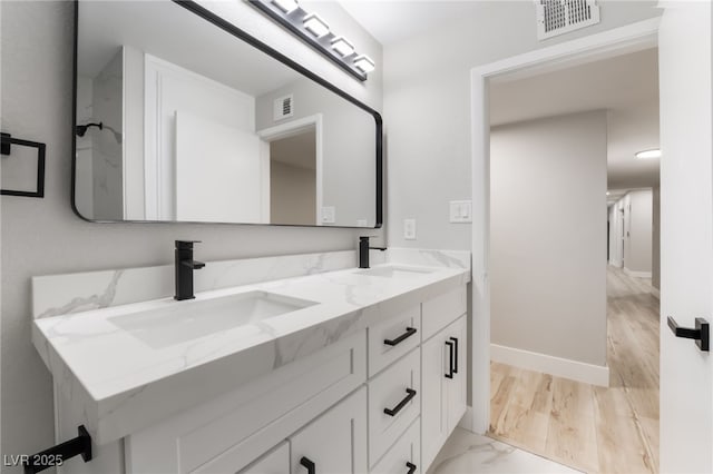 1009 Ironwood Dr, Las Vegas, NV 89108 - bathroom featuring double vanity and marble look tiles