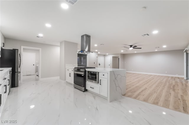 1009 Ironwood Dr, Las Vegas, NV 89108 - kitchen featuring island exhaust hood, appliances with stainless steel finishes, recessed lighting, white cabinetry, and light stone countertops