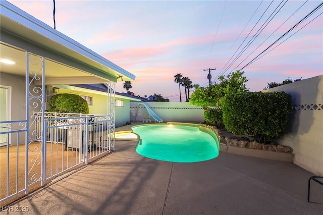 1009 Ironwood Dr, Las Vegas, NV 89108 - pool at dusk featuring a water slide, a patio, and a fenced backyard