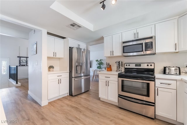 5676 Birchwood Cir, Las Vegas, NV 89120 - kitchen with stainless steel appliances, light countertops, light wood-style flooring, and white cabinets