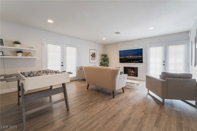 5676 Birchwood Cir, Las Vegas, NV 89120 - living area featuring french doors, a fireplace, healthy amount of natural light, wood finished floors, and recessed lighting