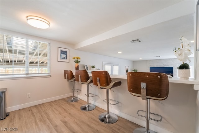 5676 Birchwood Cir, Las Vegas, NV 89120 - kitchen featuring a breakfast bar, light wood-style floors, and a fireplace