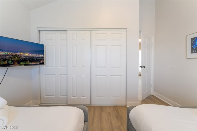 5676 Birchwood Cir, Las Vegas, NV 89120 - bedroom featuring wood finished floors, a closet, and vaulted ceiling