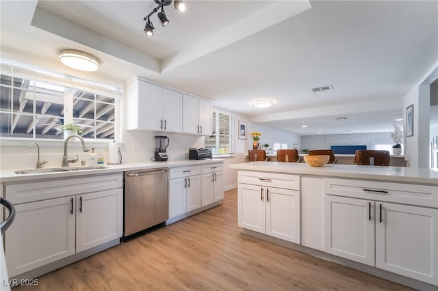 5676 Birchwood Cir, Las Vegas, NV 89120 - kitchen featuring dishwasher, white cabinets, light wood-style floors, and light countertops