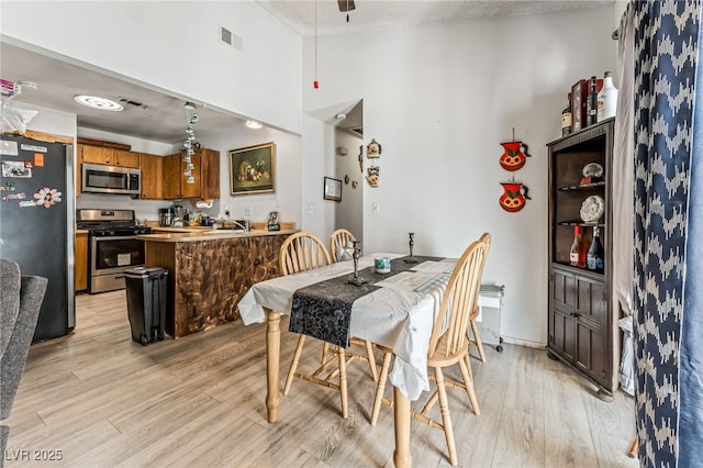 108 Sirnoble St, Las Vegas, NV 89110 - dining room with light wood finished floors, a ceiling fan, and a textured ceiling