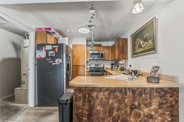 108 Sirnoble St, Las Vegas, NV 89110 - kitchen with appliances with stainless steel finishes, brown cabinets, a peninsula, light countertops, and light wood-style flooring