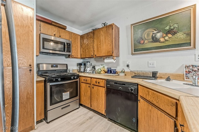 108 Sirnoble St, Las Vegas, NV 89110 - kitchen featuring stainless steel appliances, light countertops, light wood-style floors, and brown cabinets