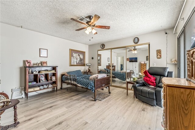 108 Sirnoble St, Las Vegas, NV 89110 - bedroom with light wood-style flooring, a textured ceiling, a closet, and a ceiling fan