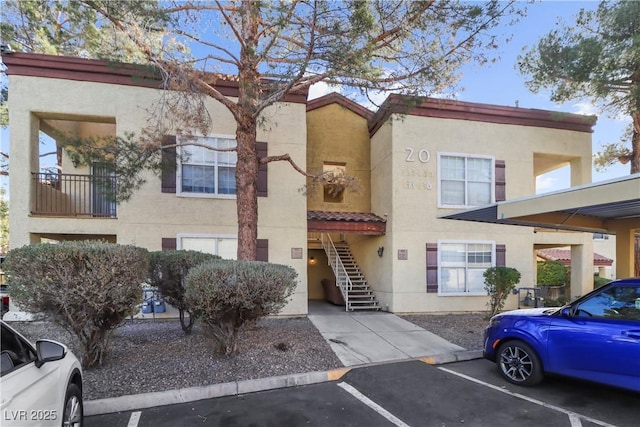 2801 N Rainbow Blvd Unit 235, Las Vegas, NV 89108 - view of front facade featuring stairs, stucco siding, uncovered parking, and a tiled roof