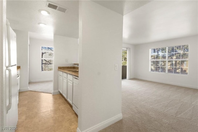 2801 N Rainbow Blvd Unit 235, Las Vegas, NV 89108 - kitchen with white cabinetry and light colored carpet